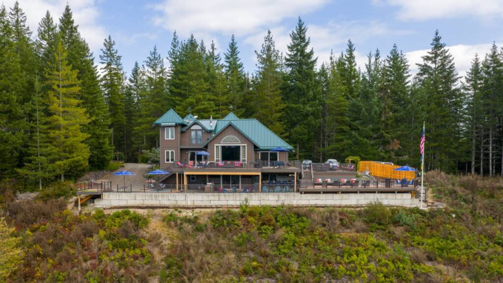 Custom home designed by Bluefoot Architecture & Design set into a forested Pacific Northwest hillside with a stepped foundation and multi-level decks
